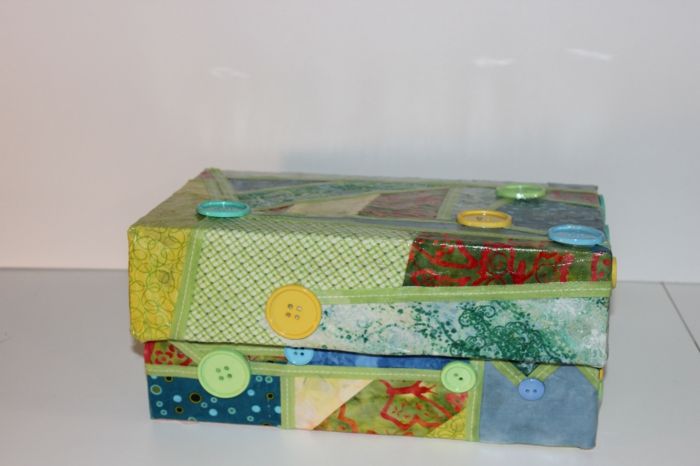 Hantverk med kartong - en collage av omslagspapper och knappar på lådan