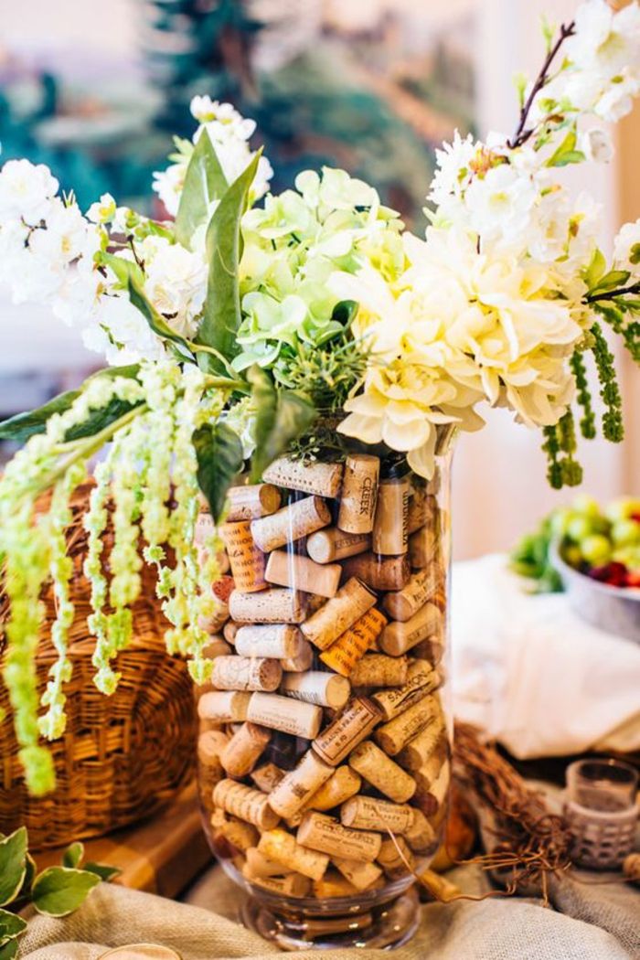 Zrób sobie dekoracja stołu, duży szklany wazon z białymi kwiatami i korkiem