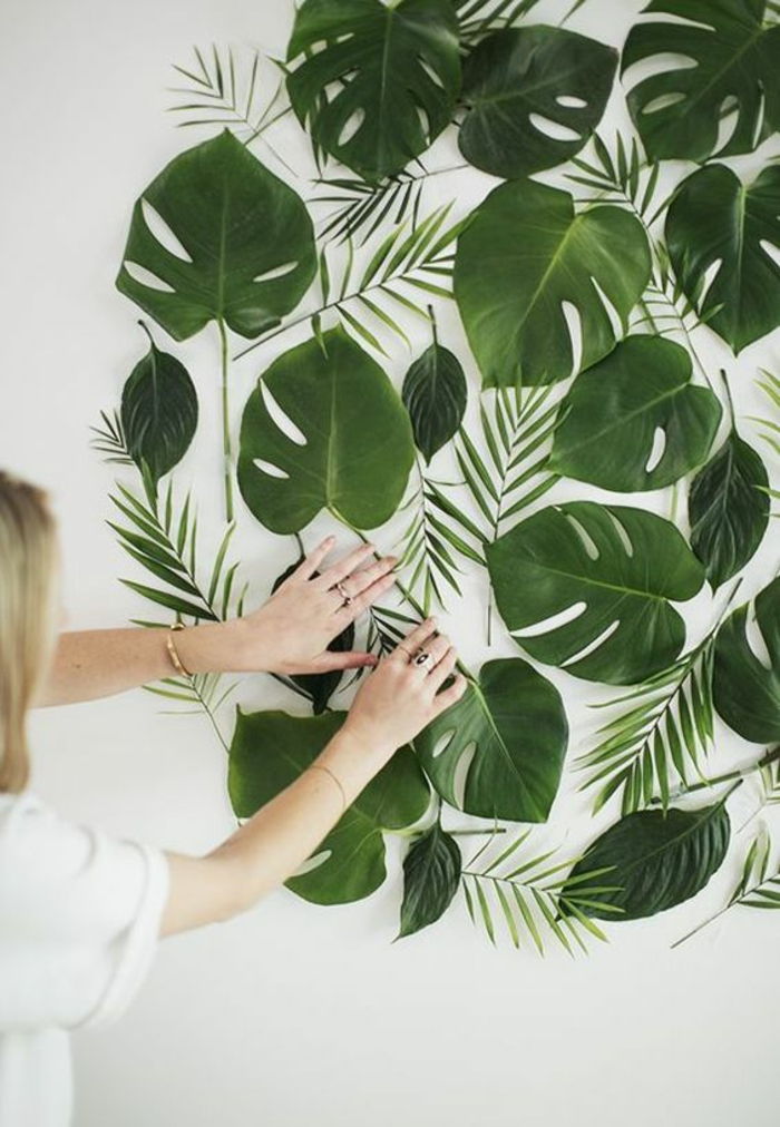 Göra väggdekoration från gröna trädblad, kvinna, blont hår, skjorta