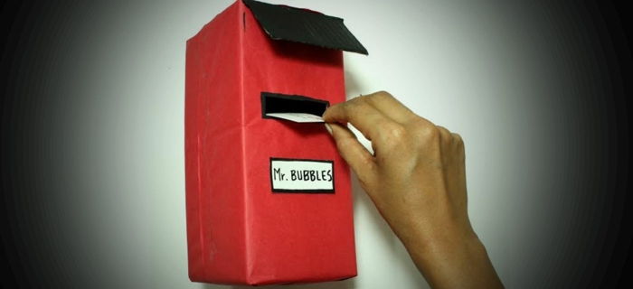 Mažoji raudona pašto dėžutė, pagaminta iš kartono drožlių, skirto p. burbulų raidėms