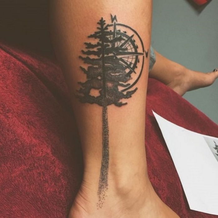 kompas tattoo pomen - ideja za veliko črno tatoo z drevesa in kompas na nogi
