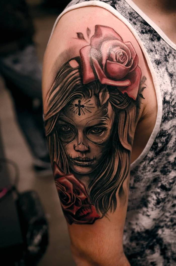 la catrina znamená - muž s tetovaním s dvoma veľkými červenými ružami a mladou ženou a malým čiernym krížom