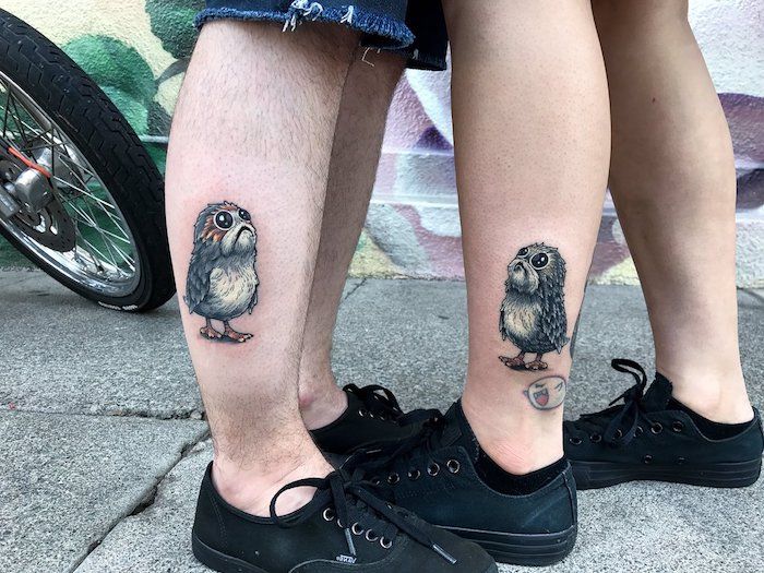 patru picioare cu tatuaje cu războaie de stele, cu un mic porg cu ochi negri și pene gri