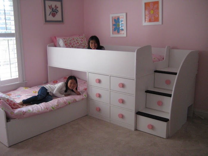 ett rosa rum med två systrar, små bilder på väggarna, loftbädd med trappor - fina rum
