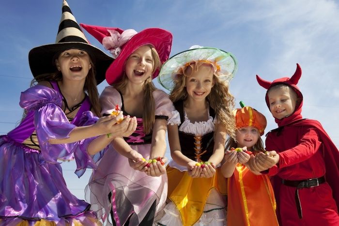 Halloween-foto's van een groep van vijf gelukkige kinderen die snoep kregen