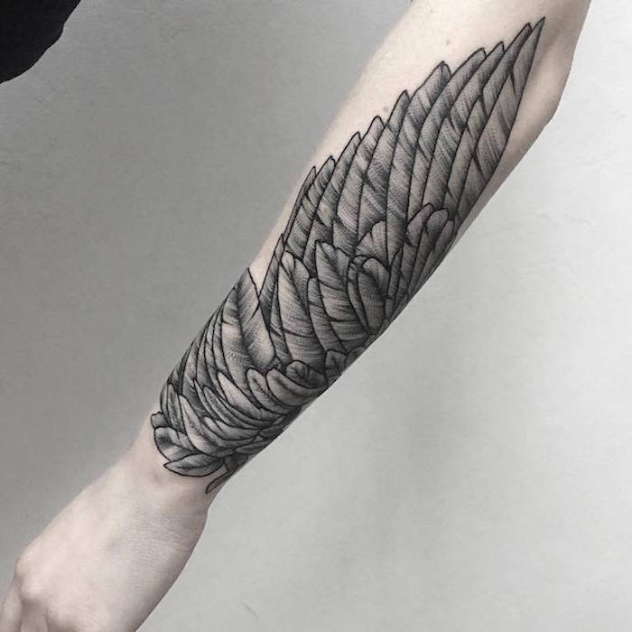 Tatuiruotė realistiška, juodos spalvos sparnas visoje rankoje kontrastas su šviesia oda