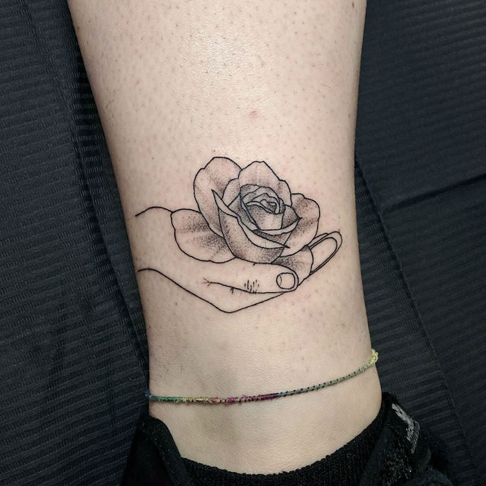 uma rosa na mão, simples tatuagem na perna tatuagem realista correspondência jóias