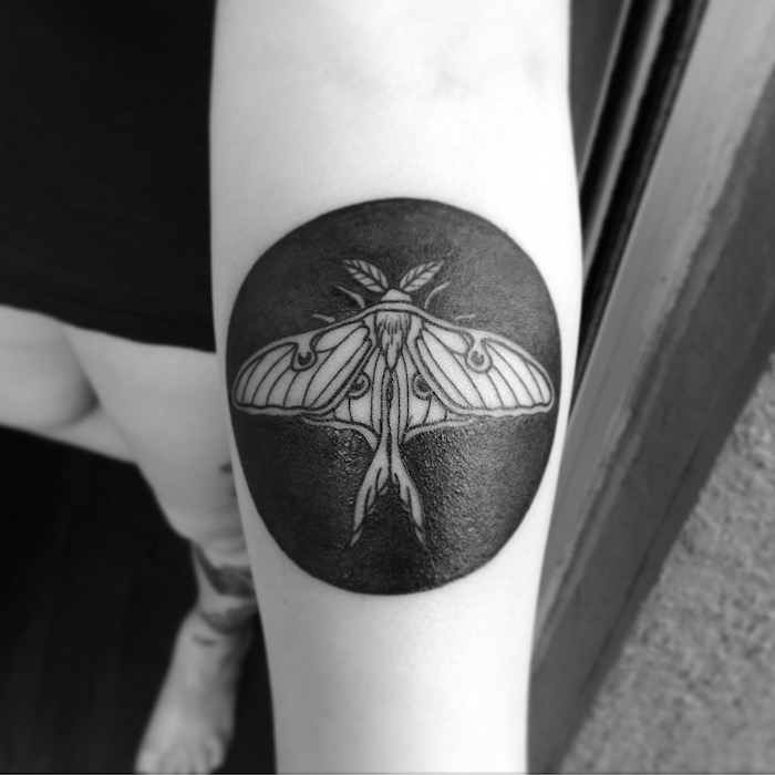 círculo preto com um inseto no centro tatuagem no braço - tipos de tatuagem