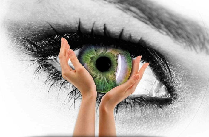 bruna gröna ögon som betyder grön ögonkonst ur ögat och gör att två händer håller ögat