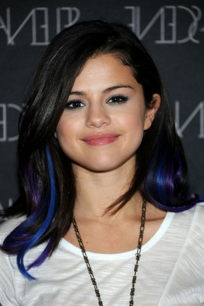 Selena Gomez, cabelos pretos com reflexos azul-escuros, maquiagem natural, blusa branca, longa corrente