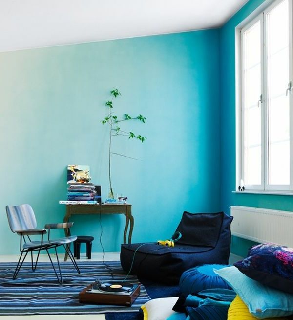 lite rom med blå vegger lenestol, teppe