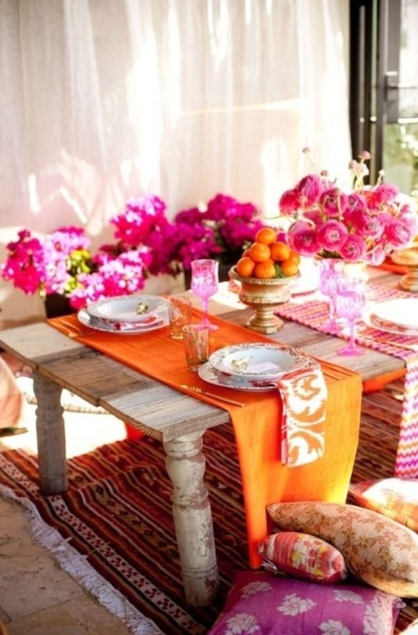 Daugelis šiuolaikinių gėlių ryškių spalvų ir oranžinių mandarinų sudaro stalą