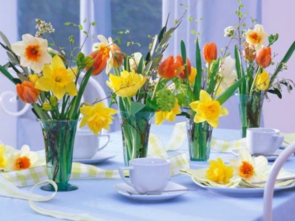 Ozdobný jedálenský stôl s vázami, kvetmi a šálkami kávy