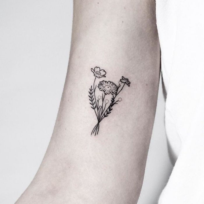 siyah ve gri küçük dövme ile kadın üst kolunda çiçek yazısı