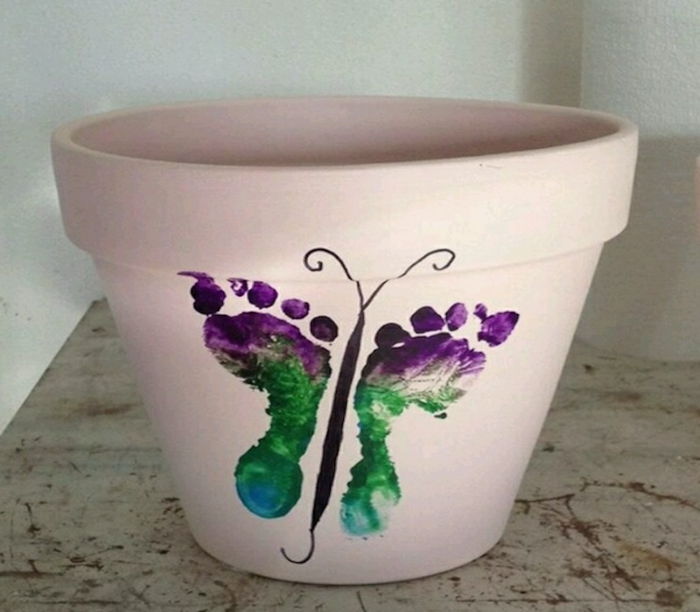 gėlių vazonai vaziuojančių dribsnių drugelis su vaiko pagalba dažomi mažos kojos ant puodelio