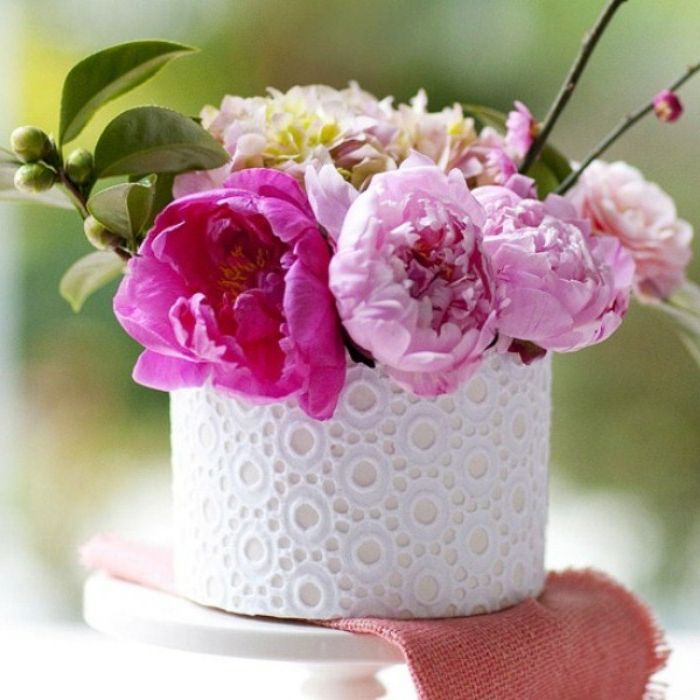 dantel ile beyaz bir saksı yapmak ve içine güzel pembe çiçekler koymak