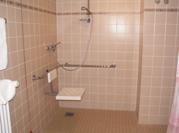 Talno-stropna tuš-v-majhni kopalnici s ploščicami v barvi breskev