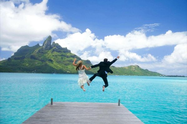 Bora Bora-semester-brygger-and-groom-jump-i-vatten