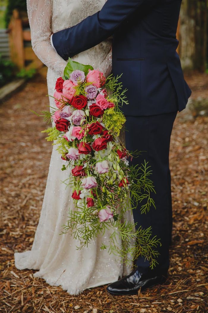 Bröllop bukett vintage avlång bukett med röda och lila rosor och många gröna växter