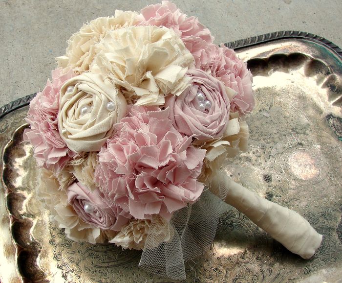 Bröllopsbukett-vintage tillverkad av tygrosa och beige-sydda blommor på brickan