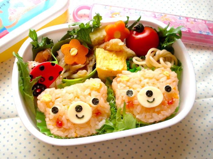 Lunchmeny för barn: Vitt ris med tomater, majs, ost och oliver, morotblommor och körsbärstomater som garnering, dekoration med nyckelpiga