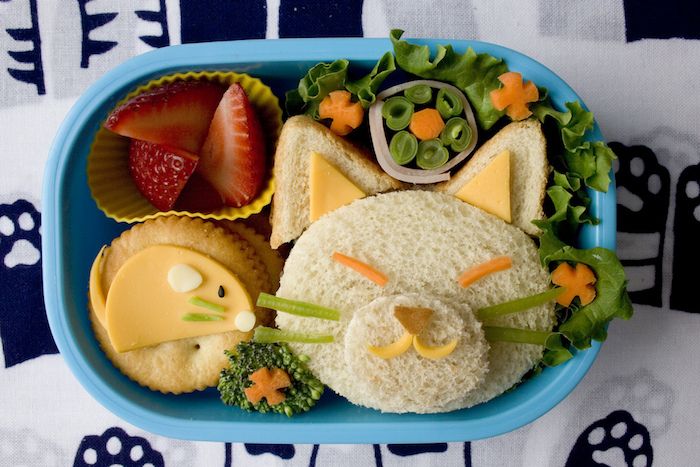 Lunch för småbarn: Smörgås i form av kattens ansikte, Grönsakspisk, Tärnad jordgubbar, Kakor med ost, Havskattsbordduk