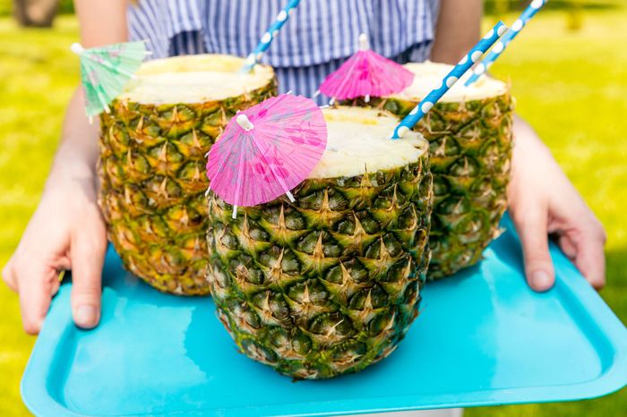 Oppskrifter til attraktive cocktailer, ananas med cocktailparaplyer, kule ideer til sommerfester