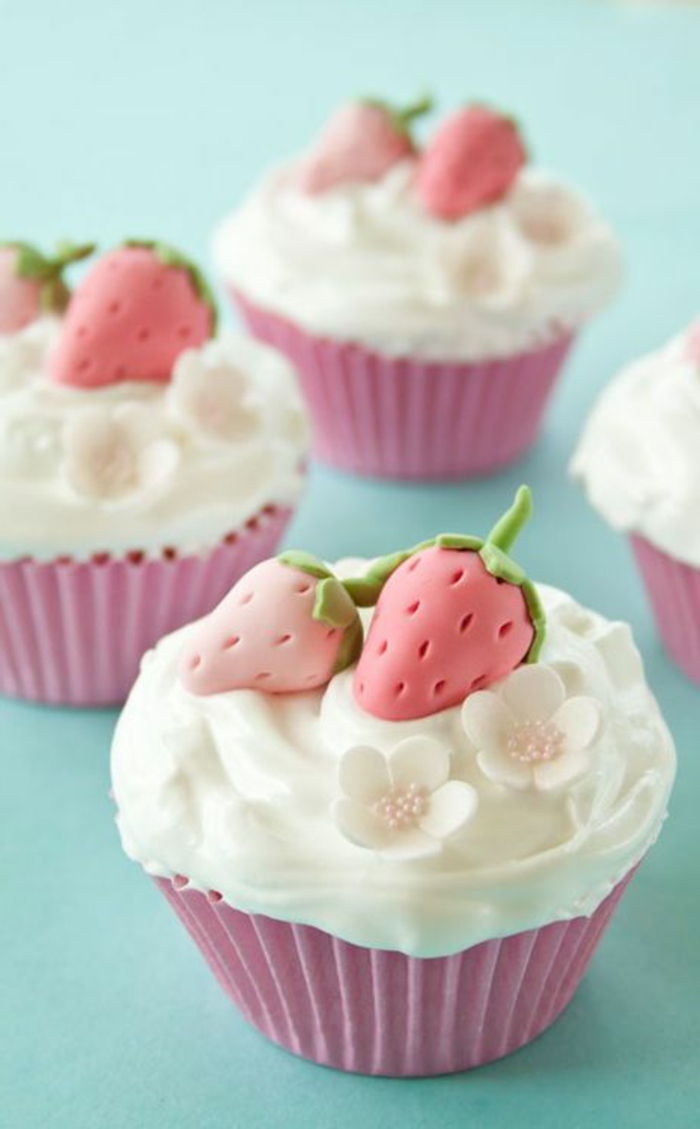muffins med hvit krem, små blomster og fondant jordbær