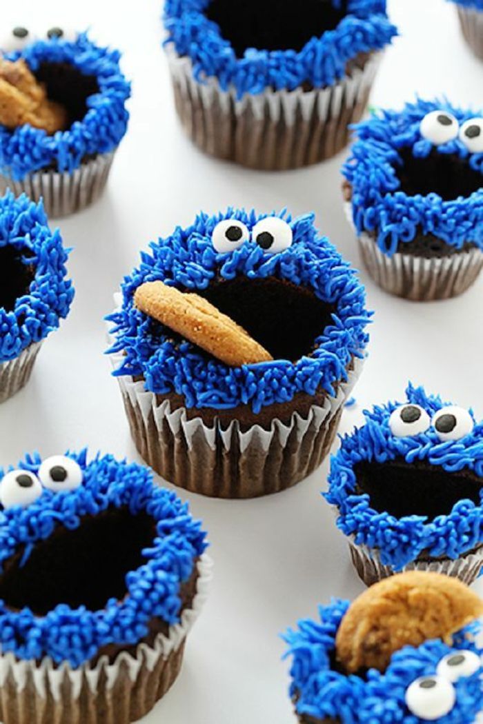 Muffins som kjeksmonsteret dekorere med kjeks og blåere krem