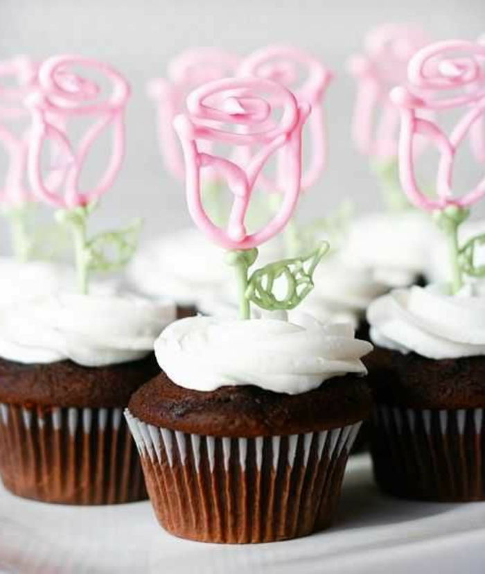 sjokolade cupcakes med krem ​​og rosa fondant roser