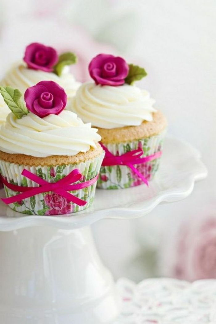 muffins med hvit krem ​​og rosa fondantroser
