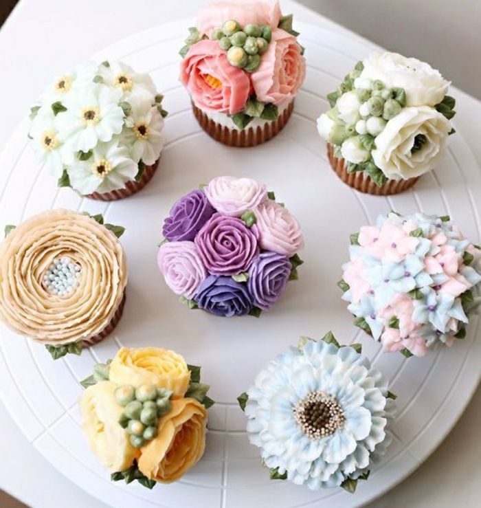 Muffins dekorert med forskjellige blomster av krem