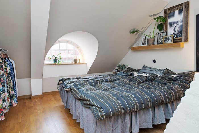 zasukana spalnica postelja design ideja okrogel okna polica posteljnina obleke