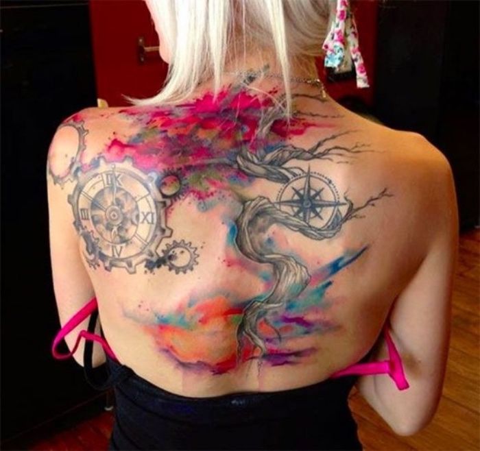 pomysł drzewa i dwóch kompasów na tatuaż kompasu na grzbiecie młodej kobiety