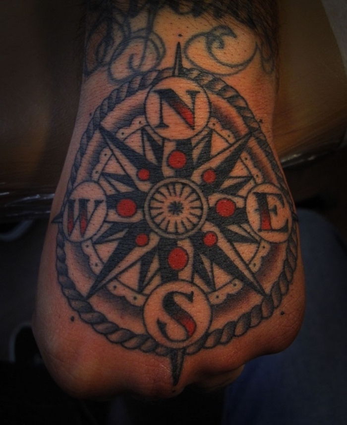 Iată o altă idee pentru un tatuaj negru mare pe mâna - un tatuaj cu busolă și puncte roșii