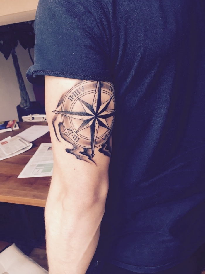 tukaj je moški z velikim črnskim tattoo nalepkam na roki - ideja za tetovažo s kompasom za moške