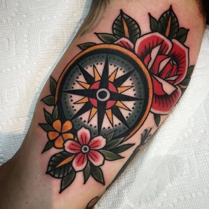 oto pomysł na mały piękny kolorowy tatuaż z kompasem z żółtymi i czerwonymi kwiatami