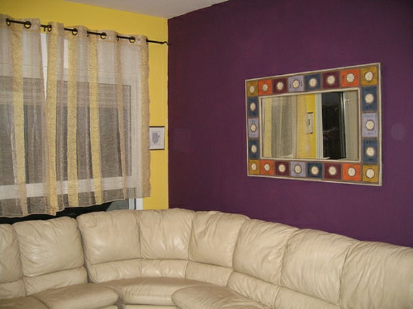 violetinės ir geltonos sienų dažai gyvenamajame kambaryje