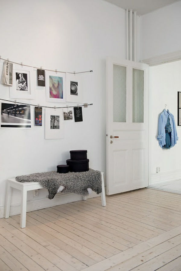liten hall med vit väggdesign och hängande bilder