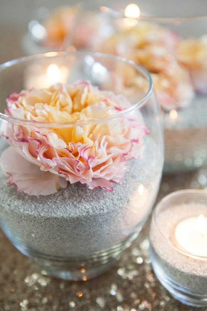 Sklenené vázy s pieskom a kvetmi, zdobenie stola, svietniky