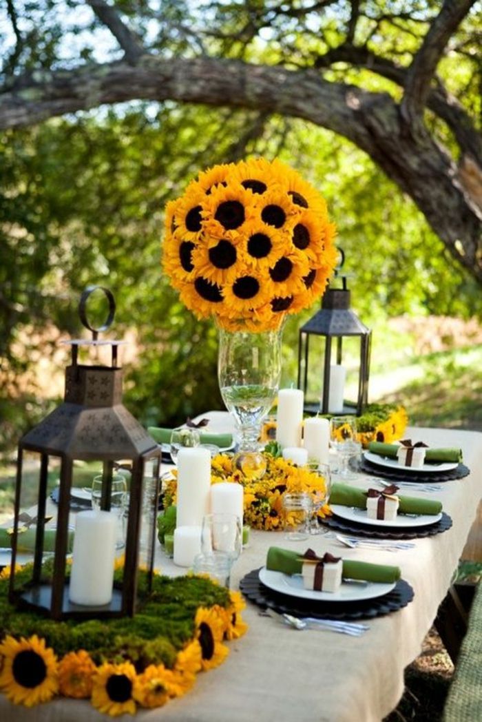 praznična okrasna miza, vrtna zabava, luči, sončnice, velika steklena vaza, majhne darilne škatle