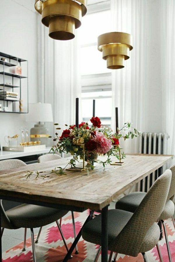 Dekoratívne kvety, drevený stôl a zlatý lustr v jedálni