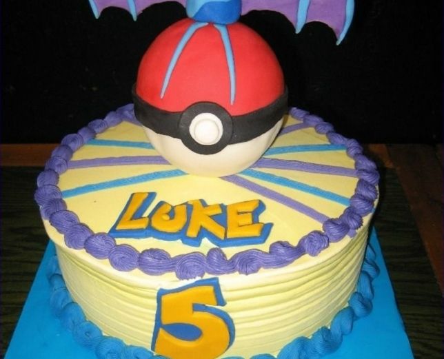 Ottima idea per una torta pokemon con una crema viola, un pokeball rosso e titoli gialli