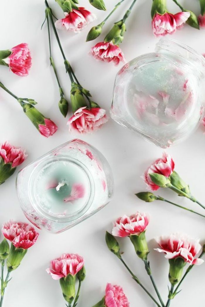 patys pagaminsi žvakes - stiklinius indus su žvakėmis, rožines gėles