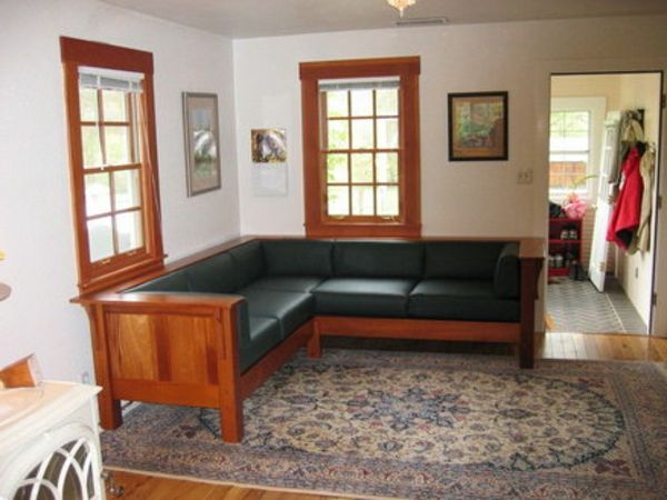 Narożna sofa obejmuje elementy w kolorze czarnym i drewniane
