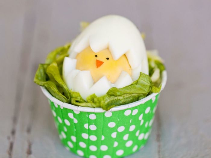 roliga påskägg med en kyckling i salladen, grön kopp med prickar