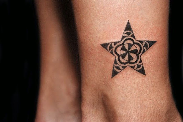 kleine zwarte tattoo - een been met een tatoeage met een zwarte sterretje