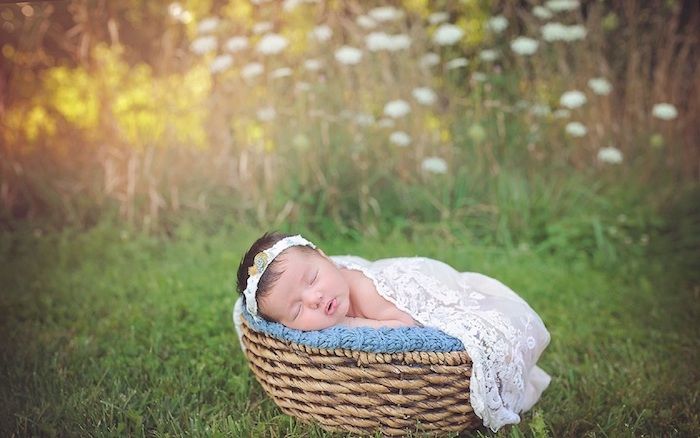 poze bune noaptea - aici este un copil mic adormit cu o rochie alba si o gradina cu multe plante verzi si flori albe si galbene