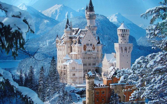 un castel alb cu turnuri și o pădure cu copaci - lac și munți în timpul iernii - imagini frumoase de iarnă