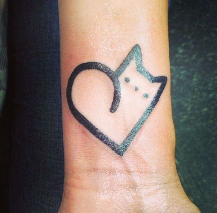 Pisica tatuaj pe încheietura mâinii - o pisică neagră cu ochi mici și o inimă